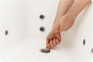 hand unclogging a drain