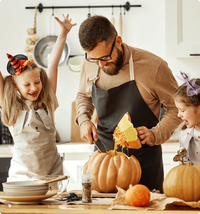 dad and kids carving a pumpkin