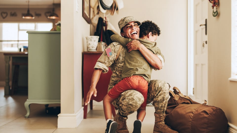 Military dad coming home from service hugging his child