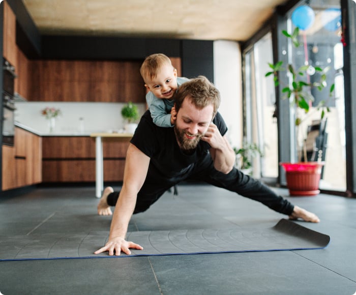 man doing a pushup with baby on his back