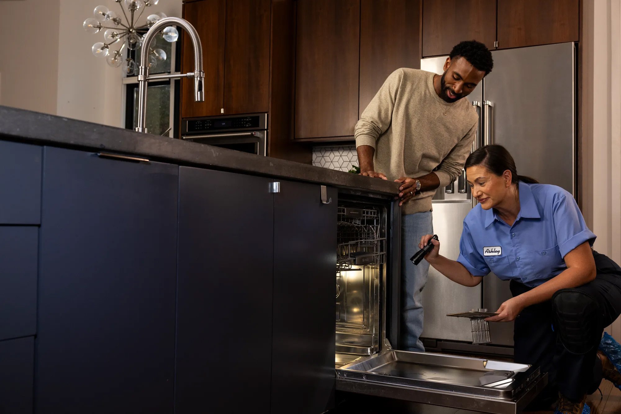 Person fixing appliance with another person