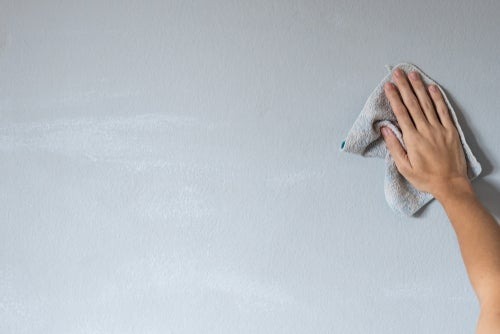wiping wall with rag