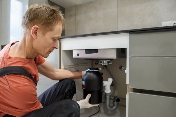 person checking garbage disposal