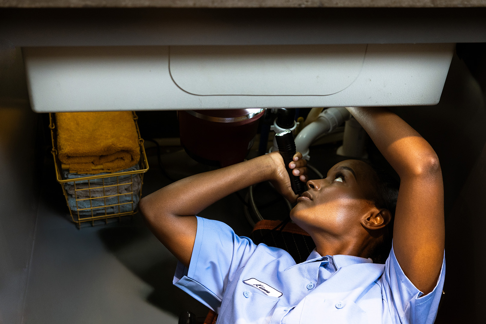 Female Pro inspecting a sink