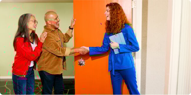 smiling people shaking hands in a doorway