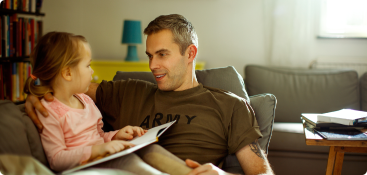 Father with Army shirt on reading with daughter